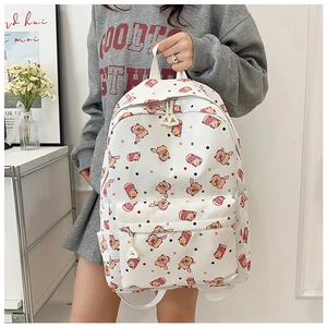 Detail of cute white backpack featuring cartoon bear print and large front zipper pocket