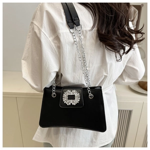 Close-up of black leather shoulder bag with silver rhinestone buckle and chain strap