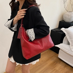 Red woven leather large tote hobo bag worn by a model in a cozy home setting