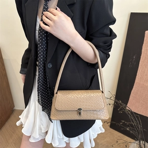 Beige faux crocodile skin baguette shoulder bag with metal buckle on model's shoulder
