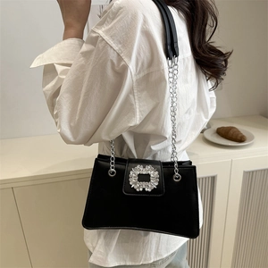 Classic black underarm bag with silver rhinestone buckle and chain strap shown on model