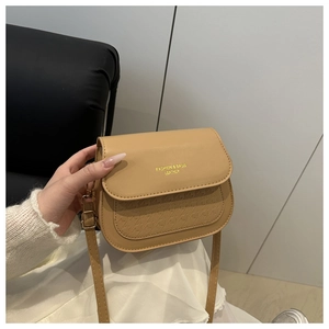 Close-up of khaki crossbody bag with embossed texture and gold fashion lettering