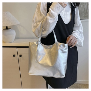 Silver metallic tote bag detail showing polished PU leather texture and shoulder strap