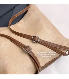 Close-up of adjustable brown leather shoulder strap with silver buckle and contrast stitching