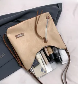 Detailed view of the spacious interior of a khaki hobo bag with cosmetics and zip detail