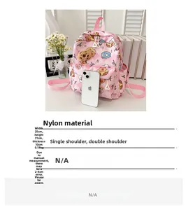 Pink nylon kids backpack features cute cartoon prints and plush charm with size details