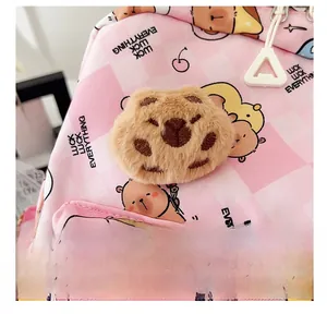 Detail of pink checkered kids backpack with a cute plush bear charm and bear patterns
