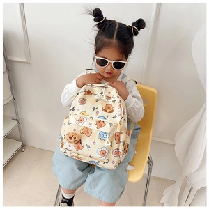 Front view of cute cartoon kids backpack with teddy bear prints and plush charm