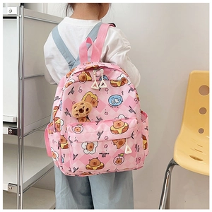 Girl wearing a pink checkered backpack with cartoon bears and a plush bear charm