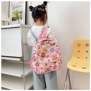 Pink cartoon toddler backpack detail featuring plush bear charm and adjustable straps