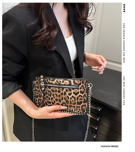Close-up of leopard print envelope bag with silver studs and metal chain strap
