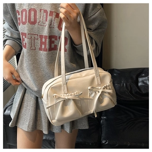 Close-up of off-white faux leather tote bag with bow-knot pockets and zip closure