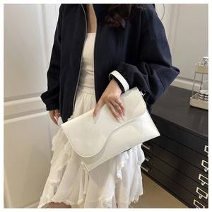 Close-up of white envelope clutch bag with asymmetric flap and wrist strap for women