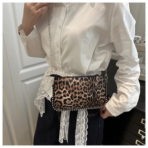 Détail du sac léopard avec clous argentés et bandoulière en chaîne métallique chic