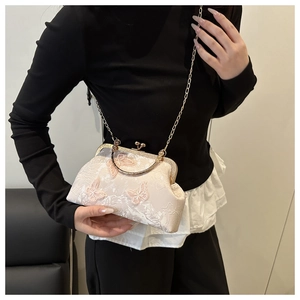 Détail du sac de soirée rose brodé de papillons avec chaîne dorée et fermoir