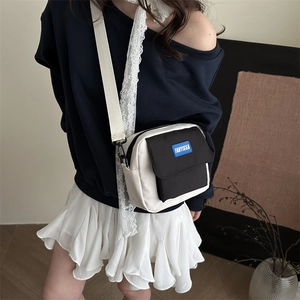 Contrast nylon crossbody bag in beige and black with adjustable strap and brand tag