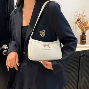 White PU leather shoulder bag with a gold bow accent, shown on a model for casual style