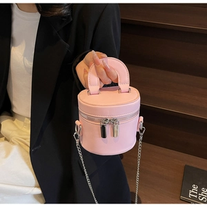 Détail du sac seau cylindrique rose avec chaîne argentée et fermeture à glissière