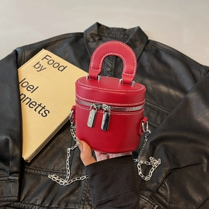 Sac cylindrique en cuir rouge avec surpiqûres contrastées et chaîne argentée