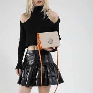 Chic beige canvas and orange leather camera bag with metallic M logo and slim strap