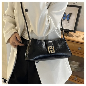 Détail du sac baguette noir en cuir verni plissé avec boucle carrée dorée