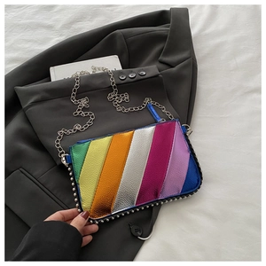 Detail of colorful metallic stripes and silver rivet trim on a chain crossbody bag