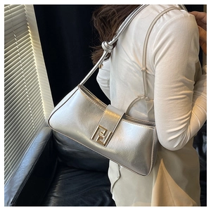 Détail du sac baguette argenté avec boucle métallique dorée double F vintage