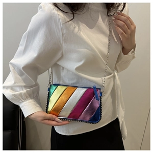 Close-up of rainbow striped crossbody bag with silver studs and metal chain strap