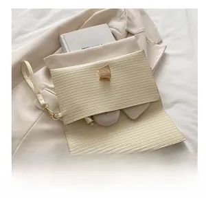 Detail of beige pleated clutch bag with gold clasp showcasing storage for makeup and phone