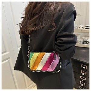 Detail of colorful metallic crossbody bag with silver studs and chain strap on a model