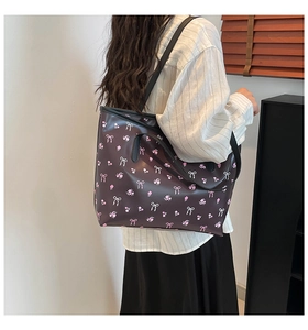 Détail du grand sac cabas noir avec motifs floraux roses et imprimés de nœuds