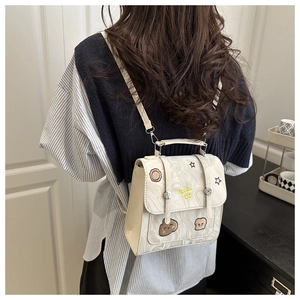 Detail of cream marble pattern mini backpack with embroidery and cartoon patches