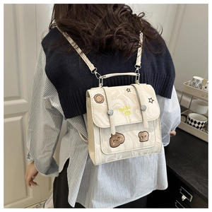 Detail of off-white marble texture backpack with embroidery and cartoon patches