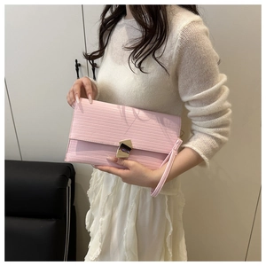 Detail of pink envelope clutch with epi texture and elegant golden metal lock clasp
