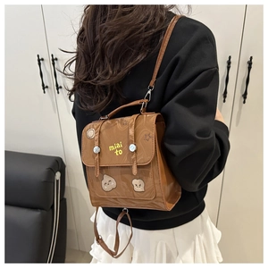 Detailed back view of a mini brown faux leather backpack with miai to embroidery