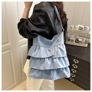 Light blue ruffle canvas tote bag shown on model highlighting tiered design and daily size
