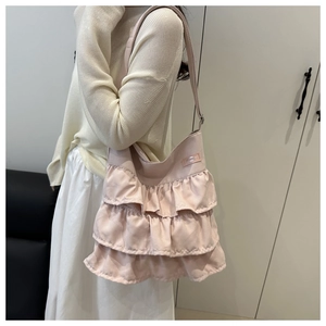 Detail of light pink shoulder bag with triple-layered ruffle pleats and smooth nylon texture