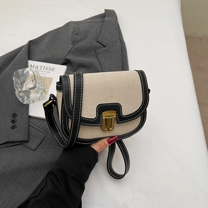 Retro canvas and black leather crossbody saddle bag with white stitching and brass lock