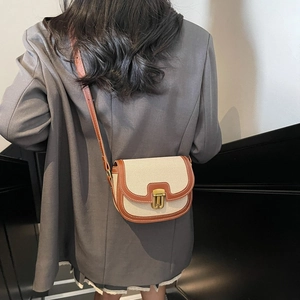 Retro canvas saddle bag with brown leather trim and brass buckle on shoulder