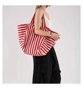 Grand sac cabas en toile à rayures rouges et blanches porté par un mannequin en studio