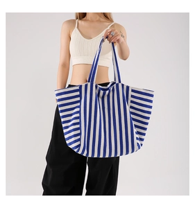 Détail d'un grand sac cabas en toile à rayures bleues et blanches au design spacieux