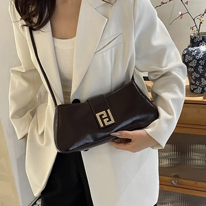 Sac baguette en cuir verni marron foncé avec boucle dorée et blazer blanc chic