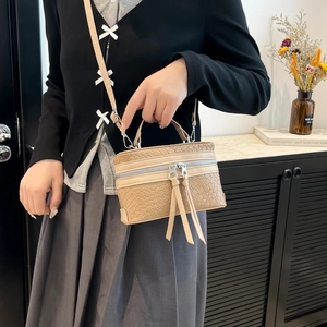 Sac à main beige tendance avec texture tissée, fermetures à glands et bandoulière