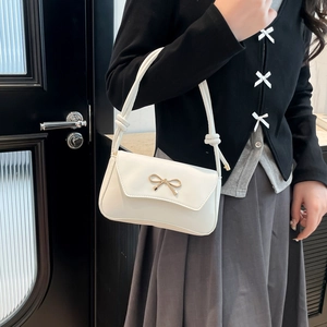 Elegant white faux leather underarm baguette bag with golden bow clasp and knot strap detail