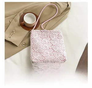 Detailed close-up of white floral lace fabric and pink handle on a large tote bag