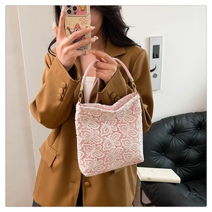 Detailed shot of pink lining and white lace floral patterns on a chic summer handbag