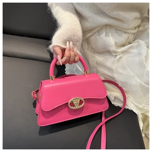 Detail of rose pink handbag with golden oval clasp and fine matte leather texture