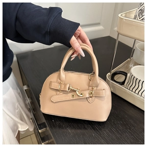Dettaglio borsa a guscio beige con chiusura in metallo dorato e trama opaca