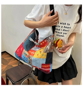 Close-up of a colorful patchwork canvas tote bag with a cute hamburger plush pendant