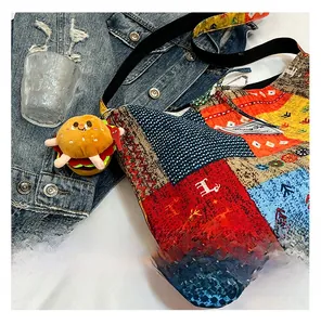 Detailed close-up of a colorful ethnic patchwork canvas tote bag with a plush burger charm